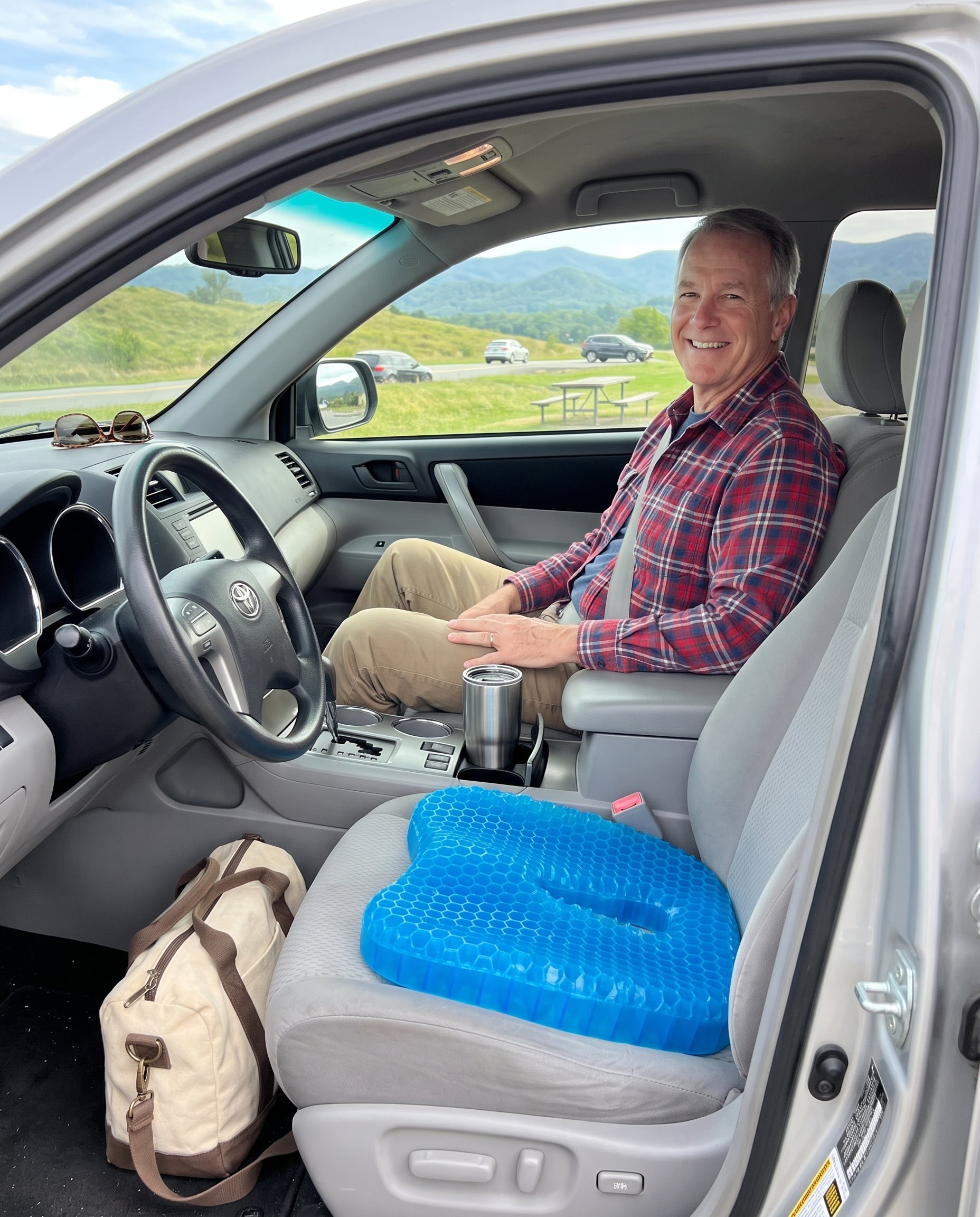 Man seated in a car with the FlexCradle cushion on the seat